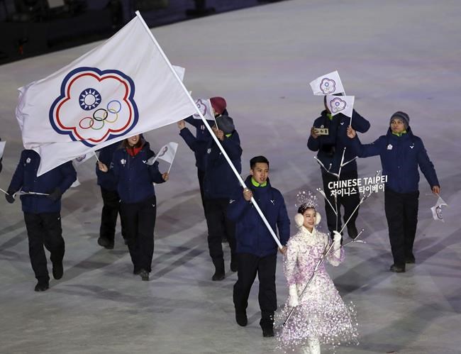 FILE - Lien Te-An, of Taiwan, carries a flag during the opening ceremony of the 2018 Winter Olympics in Pyeongchang, South Korea, Feb. 9, 2018. The four Taiwanese athletes competing in Beijing for the Winter Olympics, which open Friday, Feb. 4, 2022, can’t use Taiwan’s flag. They have long competed under a name, Chinese Taipei, that is rarely used and was forced on the team by a geopolitical divide that predates the Cold War. (AP Photo/Michael Sohn, File)