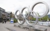 People walk past the Olympic rings in Whistler, B.C., Friday, May 15, 2020. An Indigenous-led partnership has taken the next step in exploring a potential bid to host the 2030 Winter Olympics and Paralympics. THE CANADIAN PRESS/Jonathan Hayward
