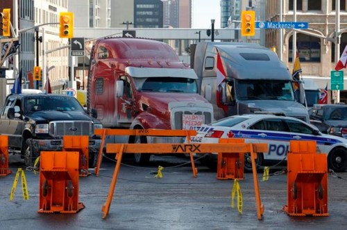 Trucks are blocked by police barricades as a rally against COVID-19 restrictions, which began as a cross-country convoy protesting a federal vaccine mandate for cross-border truckers continues in Ottawa on Tuesday, Feb. 1, 2022. Ottawa police have made two arrests following demonstration-related investigations, as the anti-vaccine mandate protest continues to keep the capital at a standstill. THE CANADIAN PRESS/Patrick Doyle