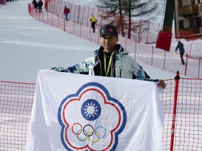 In this photo provided by Szollos Peter, Ray Ho is holds a flag in Italy on Feb. 26, 2019, created to represent Chinese Taipei, the name under which Taiwan competes under in international sporting competitions. Under an agreement struck by the Taiwan government and the IOC in 1981 they compete under the name and flag of Chinese Taipei after a referendum to change their name to Taiwan failed in 2018. (Szollos Peter via AP)