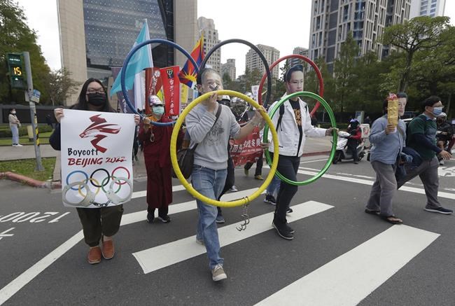 FILE - Human right groups gather on the United Nations international Human Rights Day, Dec. 10, 2021, in front of the Bank of China building in Taipei, Taiwan, to boycott the 2022 Winter Olympics in Beijing. The four Taiwanese athletes competing in Beijing for the Winter Olympics, which open Friday, Feb. 4, 2022, can’t use Taiwan’s flag. For Taiwan, every appearance on the global stage is fraught with politics, and even more so when that stage is China. (AP Photo/Chiang Ying-ying, File)