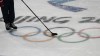A puck slides over the Olympic rings during a hockey practice at the 2022 Winter Olympics, Wednesday, Feb. 2, 2022, in Beijing. (AP Photo/Petr David Josek)