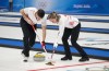 Canada's Rachel Homan and John Morris sweep a rock as they face Great Britain's Bruce Mouat and Jennifer Dodds in mixed doubles curling play at the 2022 Winter Olympics in Beijing on Thursday, February 3, 2022. THE CANADIAN PRESS/Paul Chiasson