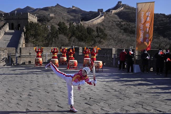 Wu Jingyu, China's Taekwondo Olympic Champion, poses with a kick before taking part in the torch relay for the 2022 Winter Olympics at the Badaling Great Wall on the outskirts of Beijing, China, Thursday, Feb. 3, 2022. (AP Photo/Ng Han Guan)