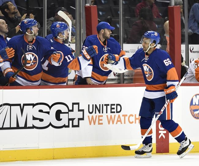 FILE- New York Islanders center Josh Ho-Sang (66) celebrates his goal against the Philadelphia Flyers with teammates in the third period of a preseason NHL hockey game in New York., Monday, Sept. 26, 2016. The 2022 Beijing Olympics will be the first time Josh Ho-Sang, the multirracial, multicultural Canadian ice hockey player, will visit China.