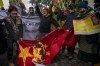 Exile Tibetans burn a Chinese flag during a protest against Beijing Winter Olympic Games in New Delhi, India, Friday, Feb. 4, 2022. Hundreds of Tibetan exiles are marching outside the Chinese Embassy in New Delhi, denouncing the Beijing Winter Olympics and demanding freedom for their region. (AP Photo/Altaf Qadri)