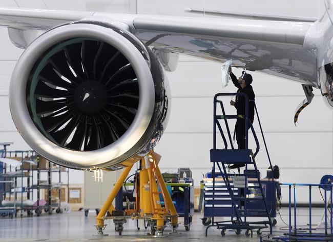 An Airbus employee works under the wing of an Airbus A220 at the assembly plant in Mirabel, Que., Thursday, Feb. 20, 2020. Quebec is maintaining a 25 per cent stake in the old C Series commercial jet program and at least 2,500 full-time jobs in the province by investing US$300 million more in the Airbus A220 aircraft. THE CANADIAN PRESS/Graham Hughes