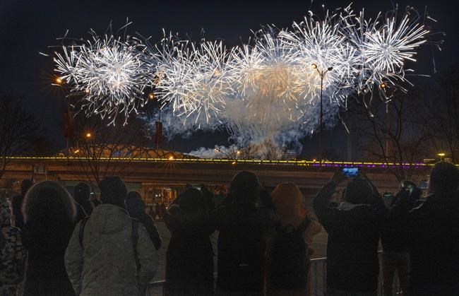 Children play as they wait in a neighbouring carpark to catch a glimpse of the fireworks for the opening ceremony of the 2022 Winter Olympics, Friday, Feb. 4, 2022, in Beijing. (AP Photo/Ng Han Guan)