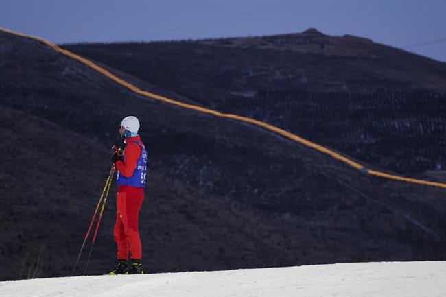 FILE - Lights illuminate a portion of the Great Wall during a cross-country skiing training session before the 2022 Winter Olympics, Thursday, Feb. 3, 2022, in Zhangjiakou, China. (AP Photo/Alessandra Tarantino, File)