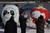A child reacts near the Winter Olympics and Paralympics mascots, Bing Dwen Dwen, and Shuey Rhon Rhon along a lake in Beijing, China, Monday, Feb. 7, 2022. As China gets back to business after a muted Chinese New Year holiday that coincided with the start of the pandemic-restricted Beijing Olympic Winter Games, the feeling inside and out of the bubble in this auspicious Year of the Tiger is that festivities for the most sacred and important holiday for the country were limited and underwhelming. (AP Photo/Ng Han Guan)