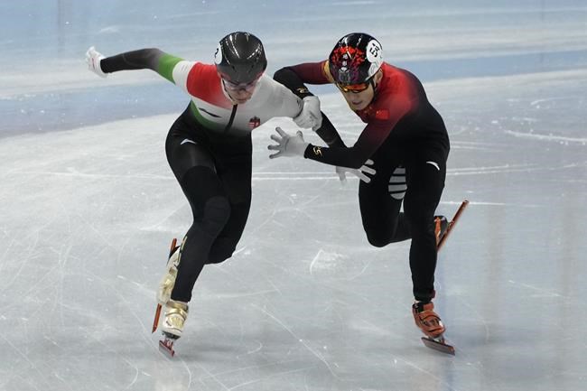 Shaolin Sandor Liu, left, of Hungary and Ren Ziwei of China, battle to cross the finish line in the final of the men's 1,000-meter during the short track speedskating competition at the 2022 Winter Olympics, Monday, Feb. 7, 2022, in Beijing. (AP Photo/Natacha Pisarenko)