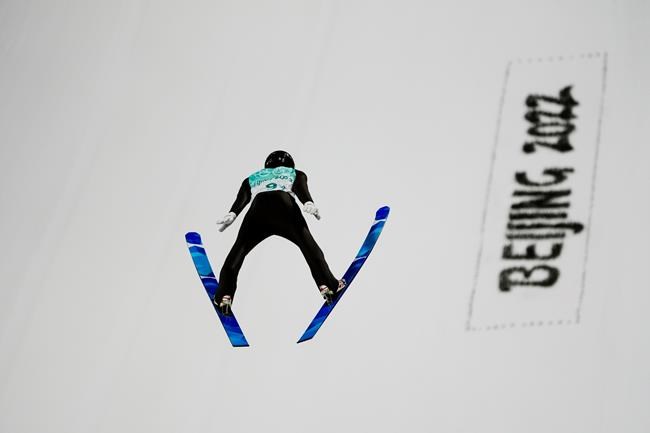 Timi Zajc, of Slovenia, soars through the air during the mixed team trial round at the 2022 Winter Olympics, Monday, Feb. 7, 2022, in Zhangjiakou, China. (AP Photo/Matthias Schrader)