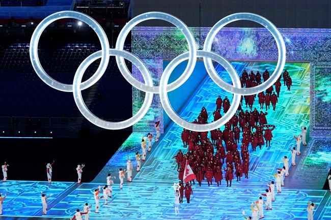 Canada flag-bearers Charles Hamelin (left) and Marie-Philip Poulin lead the Canadian athletes as they enter the stadium during the opening ceremony at the Beijing Winter Olympics in Beijing, China, on Friday, Feb. 4, 2022. THE CANADIAN PRESS/Paul Chiasson