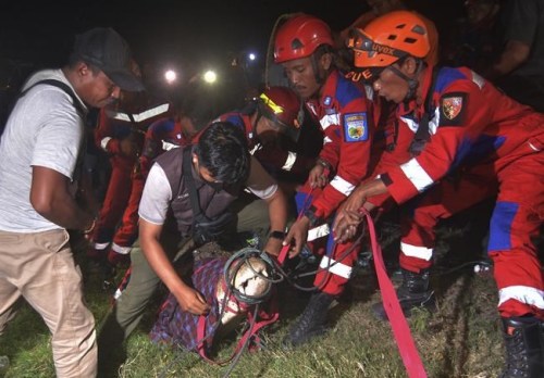 Rescuers hold a crocodile after removing a tire from its neck, in Palu, Central Sulawesi, on Feb. 7, 2022. The wild crocodile with the used motorcycle tire stuck around its neck for six years has finally been freed by an Indonesian bird catcher in a tireless effort that wildlife conservation officials hailed as a milestone. (AP Photo/Mohammad Taufan)