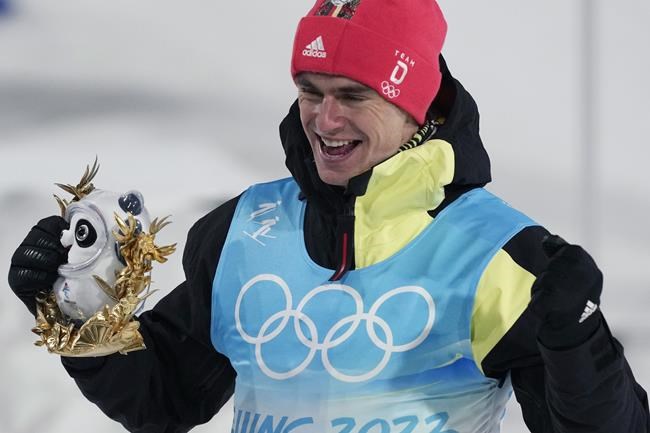 Gold medal finisher Germany's Vinzenz Geiger poses during a venue ceremony after the cross-country skiing portion of the individual Gundersen normal hill/10km event at the 2022 Winter Olympics, Wednesday, Feb. 9, 2022, in Zhangjiakou, China. (AP Photo/Aaron Favila)