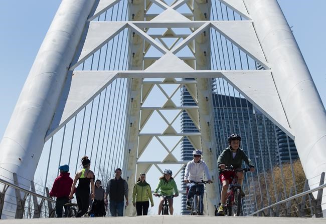People cycle and walk along the lakeshore path along Lake Ontario in Toronto on Thursday, April 2, 2020. Canada's most populous province grew at a faster pace than the rest of Canada overall over the last five years, thanks largely to immigration. THE CANADIAN PRESS/Nathan Denette
