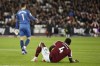 West Ham's Kurt Zouma, right, sits on the ground after a challenge during an English Premier League soccer match between West Ham United and Watford at the London stadium in London, Tuesday, Feb. 8, 2022. (AP Photo/David Cliff)