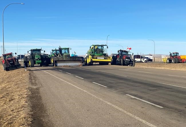 A blockade of trucks, tractors and other vehicles was still up at the Alberta-U.S. border near Coutts, Alta., on Wednesday Feb. 9, 2022. RCMP officers were met with anger and chants of 'Hell no, we won't go' as they attempted to persuade protesters against mandatory vaccines and other pandemic restrictions to move to another location. THE CANADIAN PRSS/Bill Graveland