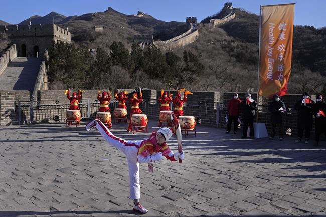 FILE - Wu Jingyu, China's Taekwondo Olympic champion, poses with a kick before taking part in the torch relay for the 2022 Winter Olympics at the Badaling Great Wall on the outskirts of Beijing, China, on Feb. 3, 2022. China has thousands of years of doing things in a really big way, reinforcing its perceived place in the world and the political power of its leaders — from emperors to Mao Zedong to Xi Jinping. None of this bigness is new. It goes back to a dozen dynasties that ruled China for thousands of years, a tradition of projecting power that was adopted by the Chinese Communist Party when it came to power in 1949. It could be termed simply: big, bigger and biggest — and then some. (AP Photo/Ng Han Guan, File)