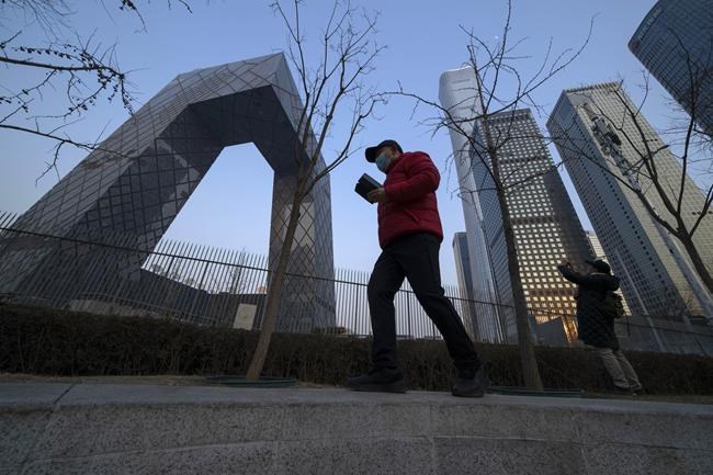 Residents walk past near the iconic Beijing headquarters of China Central TV in Beijing on Feb. 9, 2022. China has thousands of years of doing things in a really big way, reinforcing its perceived place in the world and the political power of its leaders — from emperors to Mao Zedong to Xi Jinping. None of this bigness is new. It goes back to a dozen dynasties that ruled China for thousands of years, a tradition of projecting power that was adopted by the Chinese Communist Party when it came to power in 1949. It could be termed simply: big, bigger and biggest — and then some. (AP Photo/Ng Han Guan)