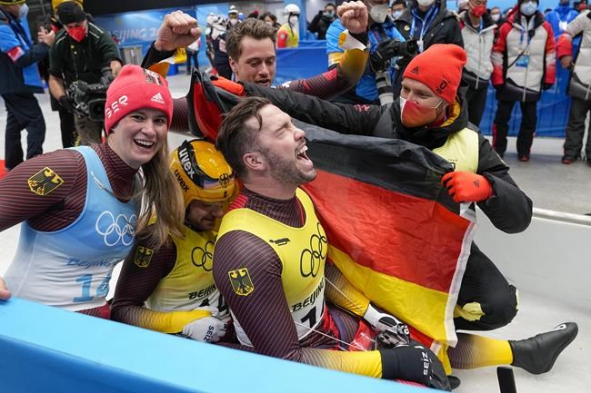 Natalie Geisenberger, Johannes Ludwig, Tobias Wendl and Tobias Arlt, of the Germany, celebrate winning the gold medal in luge team relay at the 2022 Winter Olympics, Thursday, Feb. 10, 2022, in the Yanqing district of Beijing. (AP Photo/Pavel Golovkin)