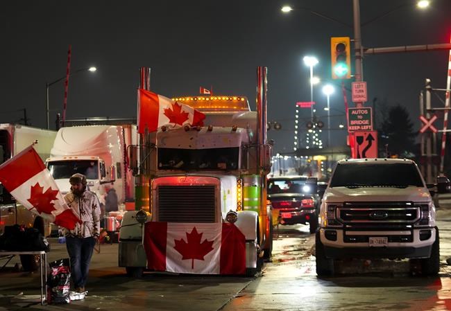 Truckers and supporters block the access leading from the Ambassador Bridge, linking Detroit and Windsor, as truckers and their supporters continue to protest against the COVID-19 vaccine mandates and restrictions in Windsor, Ont., on Wednesday, February 9, 2022. THE CANADIAN PRESS/Nathan Denette