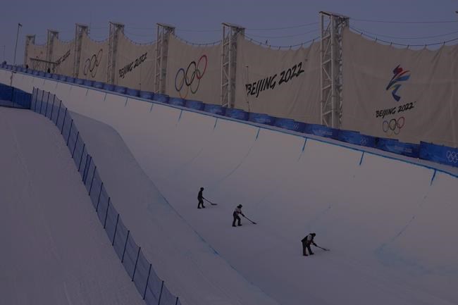 FILE - Workers prepare the halfpipe course at Genting Snow Park before the women's halfpipe finals at the 2022 Winter Olympics, Feb. 10, 2022, in Zhangjiakou, China. (AP Photo/Kiichiro Sato, File)