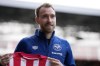 Brentford's newly signed Danish player Christian Eriksen smiles as he poses for photographs with a team shirt during his official presentation at the Community Stadium, in London, Friday, Feb. 11, 2022. Eriksen has signed with Brentford until the end of the season, almost eight months after collapsing from cardiac arrest at the European Championship. It will be a remarkable playing comeback to the English Premier League for the Denmark playmaker, who has said he was essentially dead for five minutes after collapsing in the opening Euro 2020 game against Finland. (AP Photo/Matt Dunham)