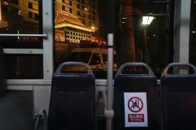 The main entrance of the Tibet Hotel is seen behind a police vehicle parked outside the hotel at the 2022 Winter Olympics, Friday, Feb. 11, 2022, in Beijing. People attending the Beijing Winter Olympics can't visit Tibet because they're in China's