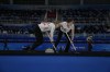 Canada's Jocelyn Peterman, left, and Kaitlyn Lawes, right, sweep during a women's curling match against Sweden at the Beijing Winter Olympics Saturday, Feb. 12, 2022, in Beijing. (AP Photo/Brynn Anderson)