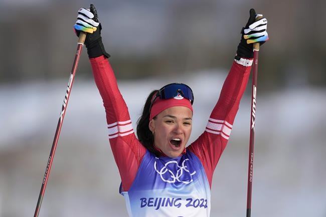 Veronika Stepanova, of the Russian Olympic Committee, celebrates after crossing the finish line during the women's 4 x 5km relay cross-country skiing competition at the 2022 Winter Olympics, Saturday, Feb. 12, 2022, in Zhangjiakou, China. (AP Photo/Aaron Favila)