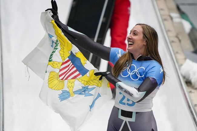 Katie Tannenbaum, of Virgin Islands, celebrates after the women's skeleton run 3 at the 2022 Winter Olympics, Saturday, Feb. 12, 2022, in the Yanqing district of Beijing. (AP Photo/Mark Schiefelbein)