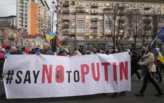 Ukrainians attend a rally in central Kyiv, Ukraine, Saturday, Feb. 12, 2022, during a protest against the potential escalation of the tension between Russia and Ukraine. Russian President Vladimir Putin and U.S. President Joe Biden are to hold a high-stakes telephone call on Saturday as tensions over a possibility imminent invasion of Ukraine escalated sharply and the U.S. announced plans to evacuate its embassy in the Ukrainian capital. (AP Photo/Efrem Lukatsky)