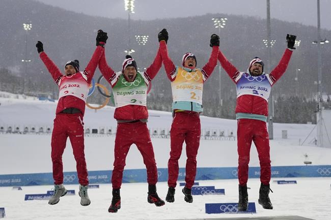 From left, Alexey Chervotkin, of the Russian Olympic Committee, Alexander Bolshunov, Denis Spitsov, and Sergey Ustiugov celebrate a gold medal finish during a venue ceremony after the men's 4 x 10km relay cross-country skiing competition at the 2022 Winter Olympics, Sunday, Feb. 13, 2022, in Zhangjiakou, China. (AP Photo/Alessandra Tarantino)