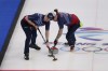 United States' Matt Hamilton, right and Colin Hufman, left, sweep during a men's curling match against Canada at the Beijing Winter Olympics Sunday, Feb. 13, 2022, in Beijing. (AP Photo/Brynn Anderson)