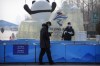 FILE - Security officers patrol near the edge of the closed-loop area on the Olympic Green near the main media center at the 2022 Winter Olympics in Beijing, Jan. 30, 2022. (AP Photo/Mark Schiefelbein, File)