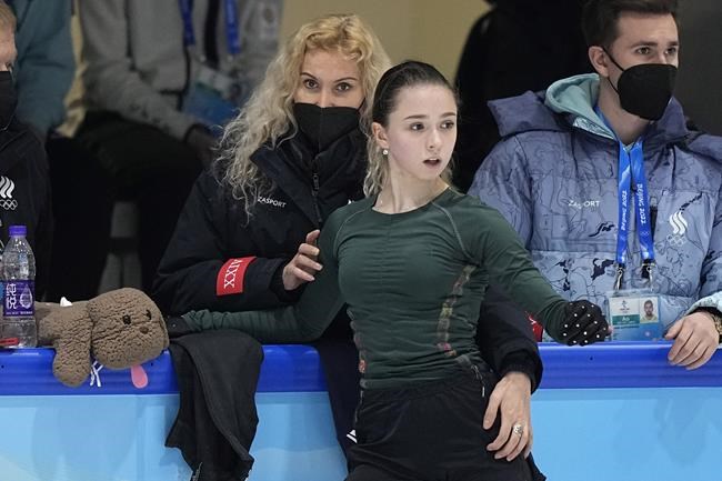 Coach Eteri Tutberidze, left, talks to Kamila Valieva, center, of the Russian Olympic Committee, during a training session at the 2022 Winter Olympics, Sunday, Feb. 13, 2022, in Beijing. (AP Photo/David J. Phillip)