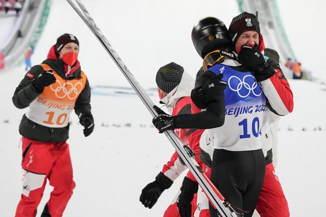Manuel Fettner, of Austria, celebrates with teammats after they won gold in the men's team ski jumping event at the 2022 Winter Olympics, Monday, Feb. 14, 2022, in Zhangjiakou, China. (AP Photo/Matthias Schrader)