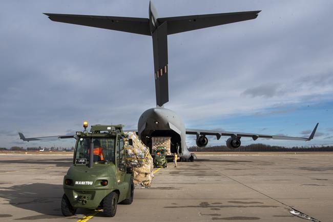 In this photo provided by Lithuanian Ministry of National Defense, Lithuania's servicemen load Stinger anti-aircraft systems, and body armor vests into military cargo plane, as part of the Lithuania's security assistance to Ukraine at the Siauliai airbase, some 230 km (144 miles) east of the capital Vilnius, Lithuania, Saturday, Feb. 12, 2022. US State Department had allowed Lithuania, Latvia and Estonia to send US-made weaponry to Ukraine, including Lithuania's anti-tank Stinger missiles. (Lithuanian Ministry of National Defense via AP)