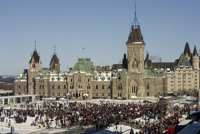 Protesters gather on Parliament hill as trucks continue to block the downtown core in protest of COVID-19 restrictions in Ottawa, Saturday, Feb. 5, 2022. THE CANADIAN PRESS/Adrian Wyld