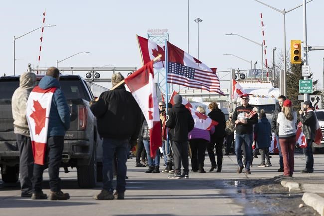Protesters block traffic at the Ambassador Bridge, linking Windsor, Ontario and Detroit on Wednesday, February 9, 2022. The demonstration in solidarity with protests in Ottawa against COVID-19 restrictions blocked traffic into Canada on the Ambassador Bridge linking Windsor and Detroit. It is the single busiest commercial crossing in North America. THE CANADIAN PRESS/Nicole Osborne