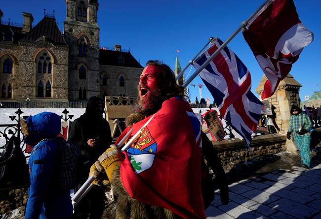 A protester yells “freedom” towards a person who attempted to stick a paper sign on a truck criticizing the so called “Freedom Convoy,” a protest against COVID-19 measures that has grown into a broader anti-government protest, on its 18th day, in Ottawa, on Monday, Feb. 14, 2022. THE CANADIAN PRESS/Justin Tang