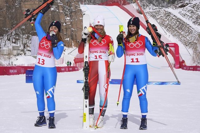 From left: Sofia Goggia, of Italy, silver, Corinne Suter, of Switzerland, gold, and Nadia Delago, of Italy, bronze, react during the medal ceremony for the women's downhill at the 2022 Winter Olympics, Tuesday, Feb. 15, 2022, in the Yanqing district of Beijing. (AP Photo/Luca Bruno)