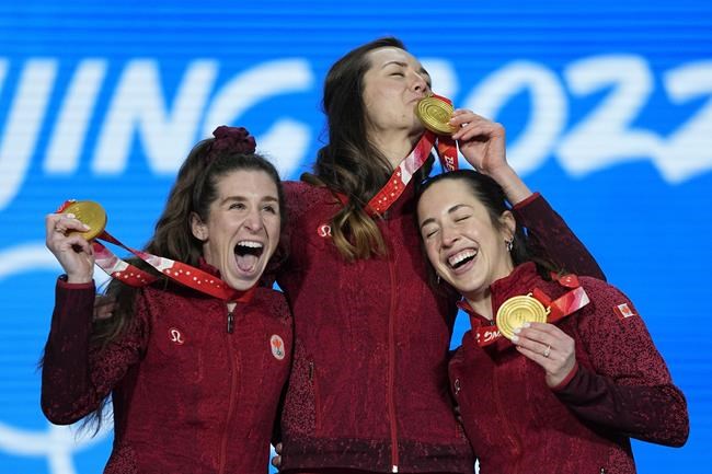 Valerie Maltais (right) Ivanie Blondin (left) and Isabelle Weidemann of Canada celebrate with their gold medals during a medal ceremony for the speedskating women's team pursuit at the 2022 Winter Olympics, Tuesday, Feb. 15, 2022, in Beijing. THE CANADIAN PRESS/AP/Jae C. Hong