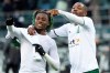 Moenchengladbach's Kouadio Kone, left, and Marcus Thuram celebrate after winning the German Bundesliga soccer match between Borussia Moenchengladbach and FC Augsburg in Moenchengladbach, Germany, Saturday, Feb. 12, 2022. (Federico Gambarini/dpa via AP)