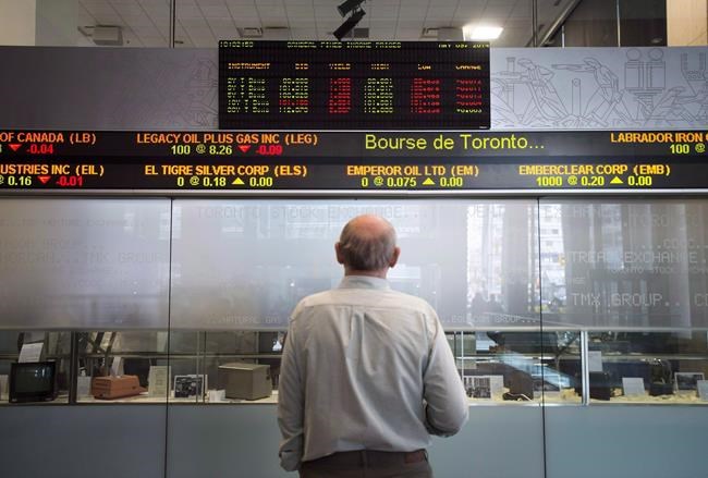 A man watches the financial numbers on the digital ticker tape at the TMX Group in Toronto's financial district on Friday, May 9, 2014. THE CANADIAN PRESS/Darren Calabrese