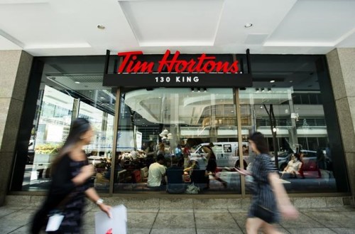 People walk past a newly-renovated Tim Hortons in Toronto, Thursday, July 25, 2019.&nbsp;Tim Hortons says its popular Iced Capp beverage will be available later this week after a supply disruption briefly pulled the frozen coffee drink from some restaurants. THE CANADIAN PRESS/Nathan Denette