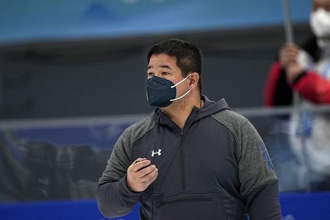 Ryan Shimabukuro, a coach for the United States speedskating team, works during the men's speedskating 1,500-meter race at the 2022 Winter Olympics, Tuesday, Feb. 8, 2022, in Beijing. (AP Photo/Ashley Landis)