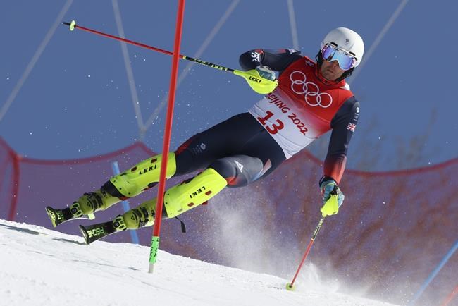 Dave Ryding, of Britain approaches a gate during the first run of the men's slalom at the 2022 Winter Olympics, Wednesday, Feb. 16, 2022, in the Yanqing district of Beijing. (AP Photo/Alessandro Trovati)