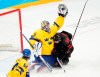Team Sweden goaltender Lars Johansson (31) makes a save as Team Canada forward Landon Ferraro (39) slides into him and Sweden defenceman Jonathan Pudas (64) looks on during second period men's quarter-final hockey action at the Beijing Winter Olympics in Beijing, China, on Wednesday, Feb. 16, 2022. THE CANADIAN PRESS/Ryan Remiorz